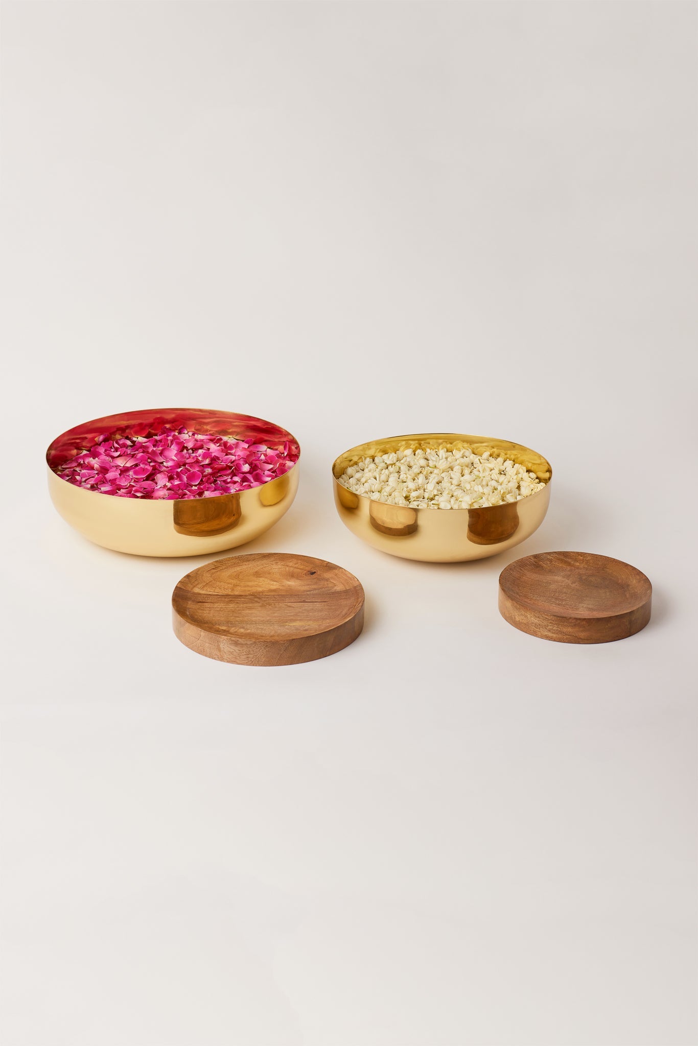 Fleck Footed Brass Urlis filled with flowers along with Wooden Bases